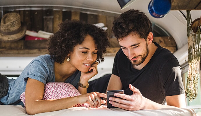 Cep telefonuna bakan bir adam ve bir kadın